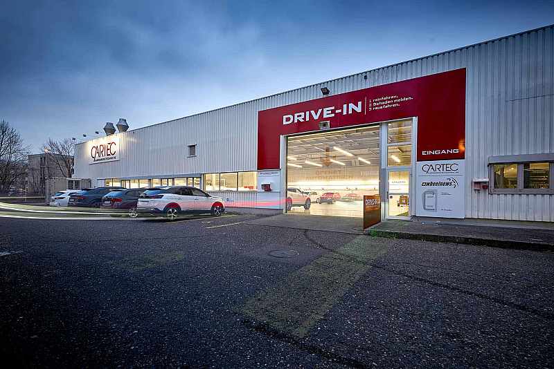 Eingangsbereich mit Kundenparkplätzen und Drive-in Buchs AG